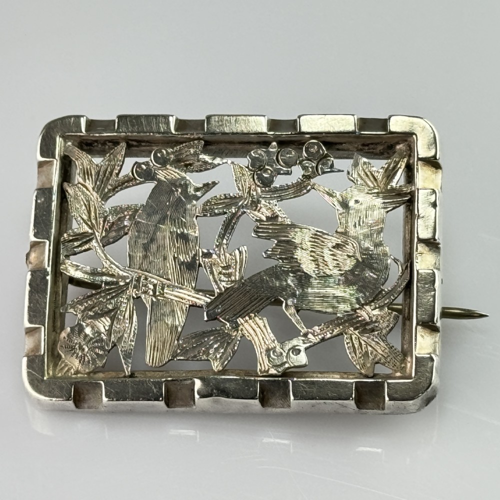 An antique rectangular silver openwork brooch depicting two detailed birds surrounded by foliage and berries. View III