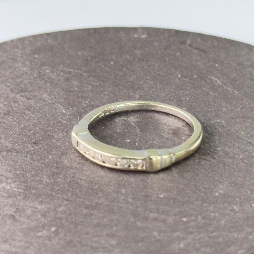 A 9ct gold half eternity ring featuring a channel-set row of round diamonds along the band. View II
