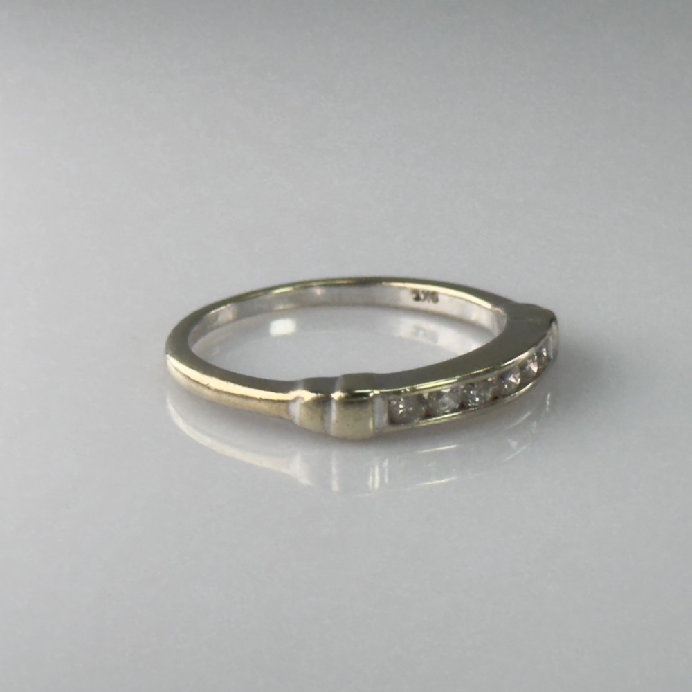 A 9ct gold half eternity ring featuring a channel-set row of round diamonds along the band. View IV