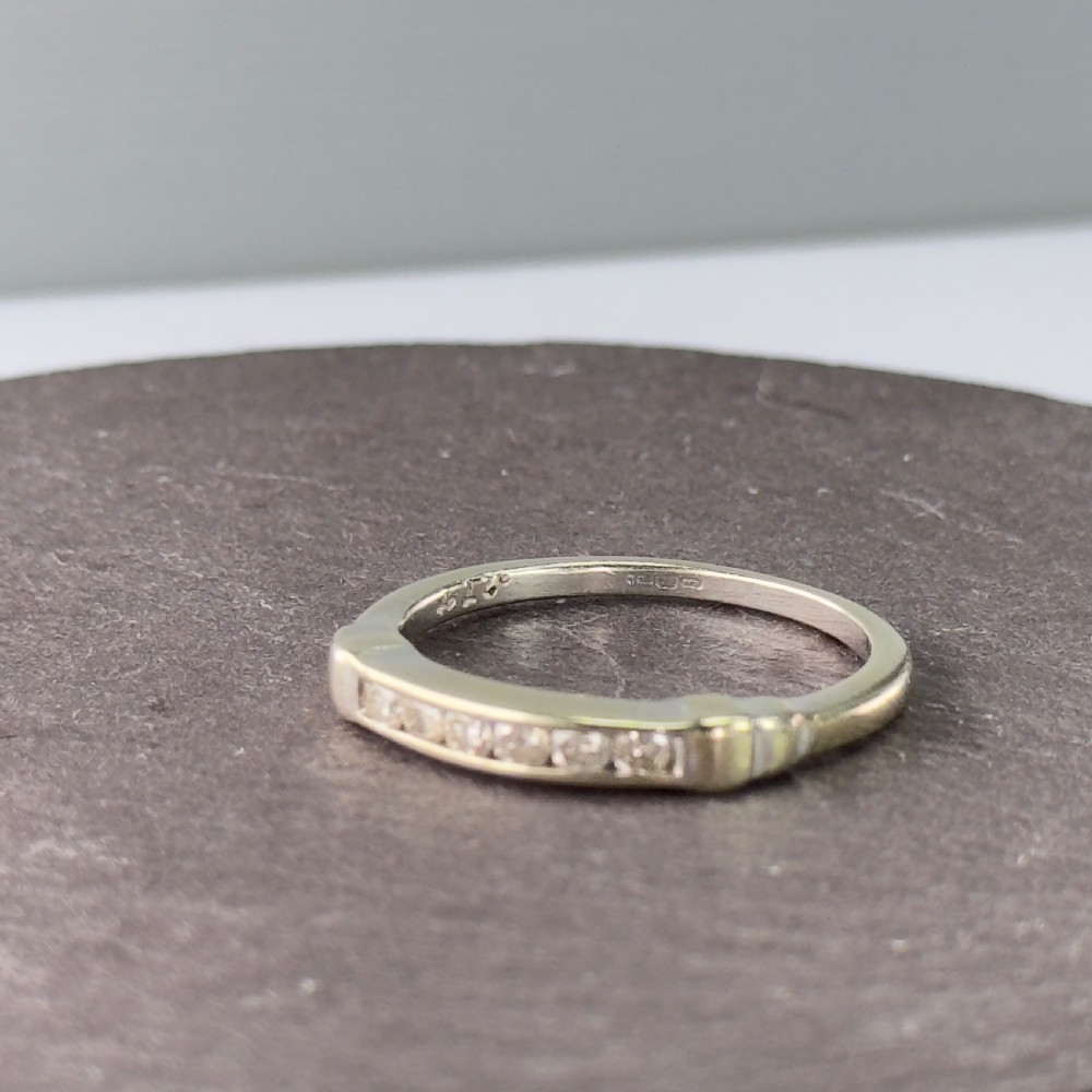A 9ct gold half eternity ring featuring a channel-set row of round diamonds along the band. View VI