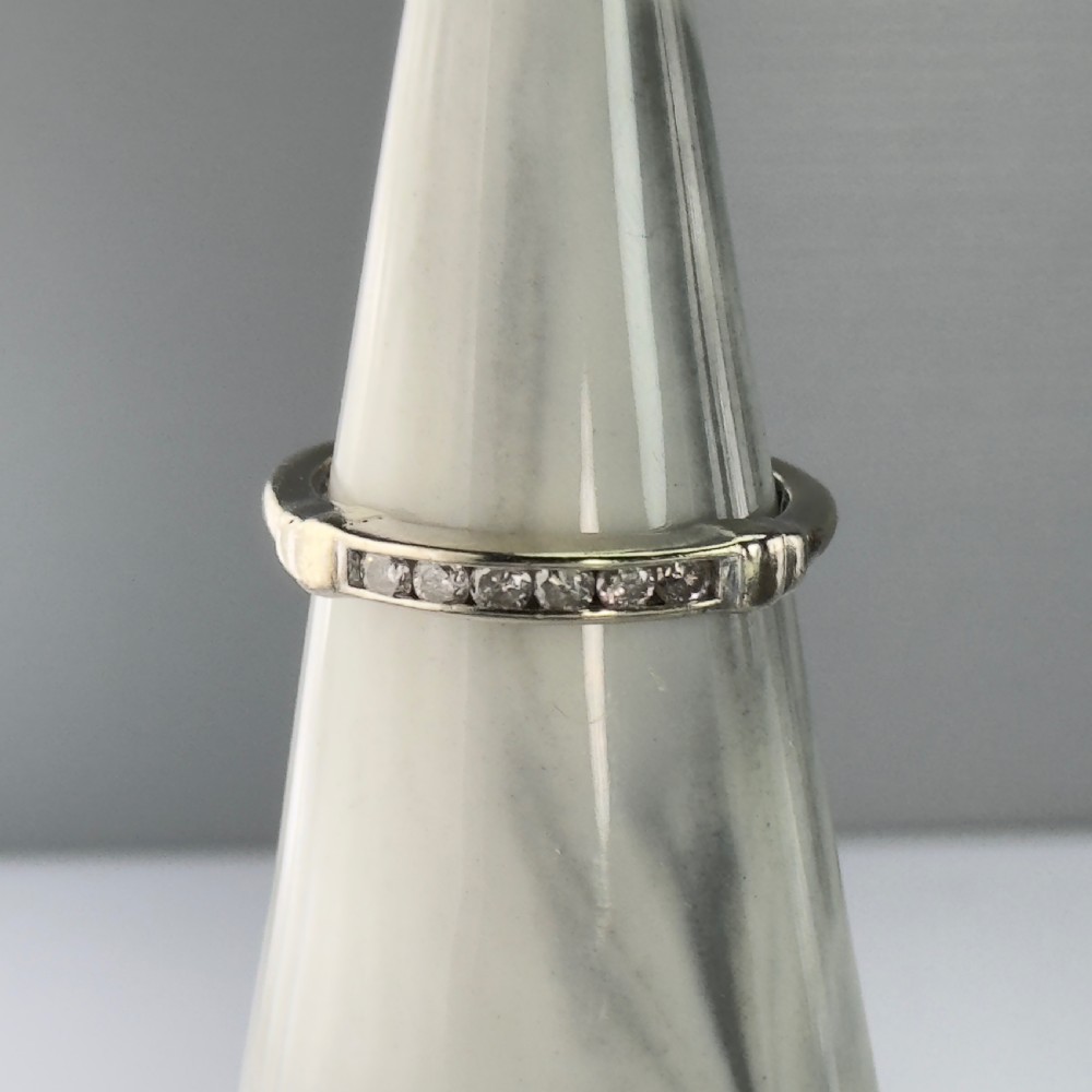 A 9ct gold half eternity ring featuring a channel-set row of round diamonds along the band. View VII