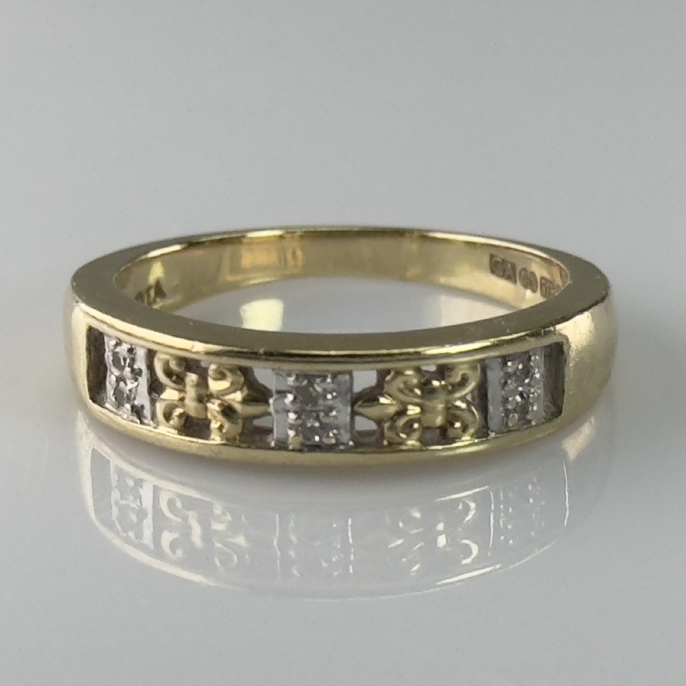 A 9ct yellow gold band featuring alternating square diamond-set panels and openwork scroll motifs with visible internal hallmarks.