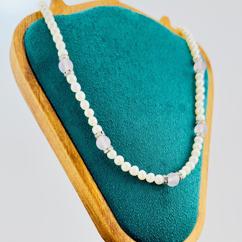A single strand necklace composed of white cultured pearls interspersed with round pale pink rose quartz beads and silver-toned paste stone spacer rondelles. View II