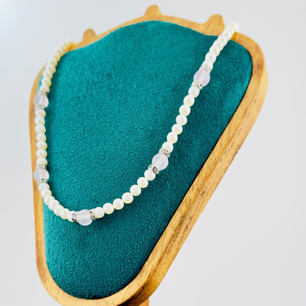 A single strand necklace composed of white cultured pearls interspersed with round pale pink rose quartz beads and silver-toned paste stone spacer rondelles. View III