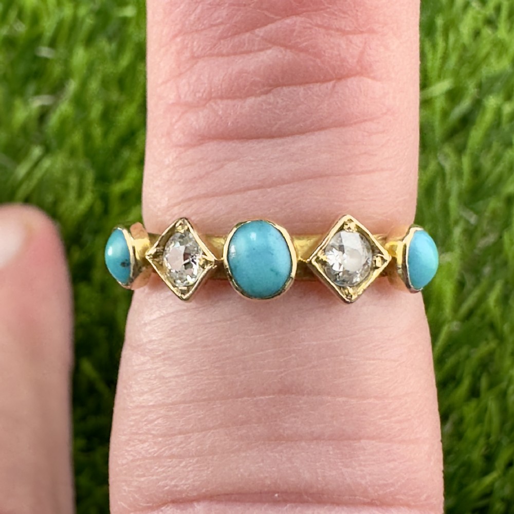 An 18ct yellow gold ring set with three cabochon blue turquoise stones alternating with two diamond-shaped collets housing round diamonds.