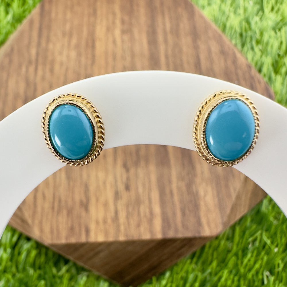 A pair of oval turquoise cabochon stud earrings set in 9ct yellow gold with rope twist border detail.