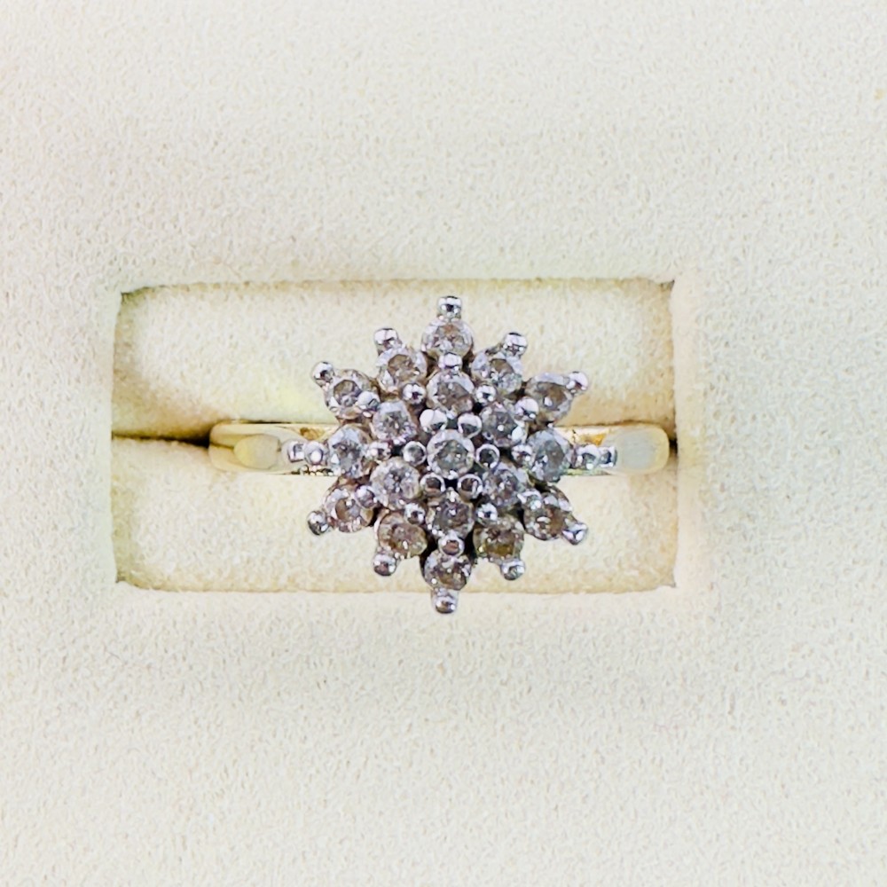 An 18ct yellow gold ring featuring a raised multi-diamond cluster setting in a circular starburst motif.