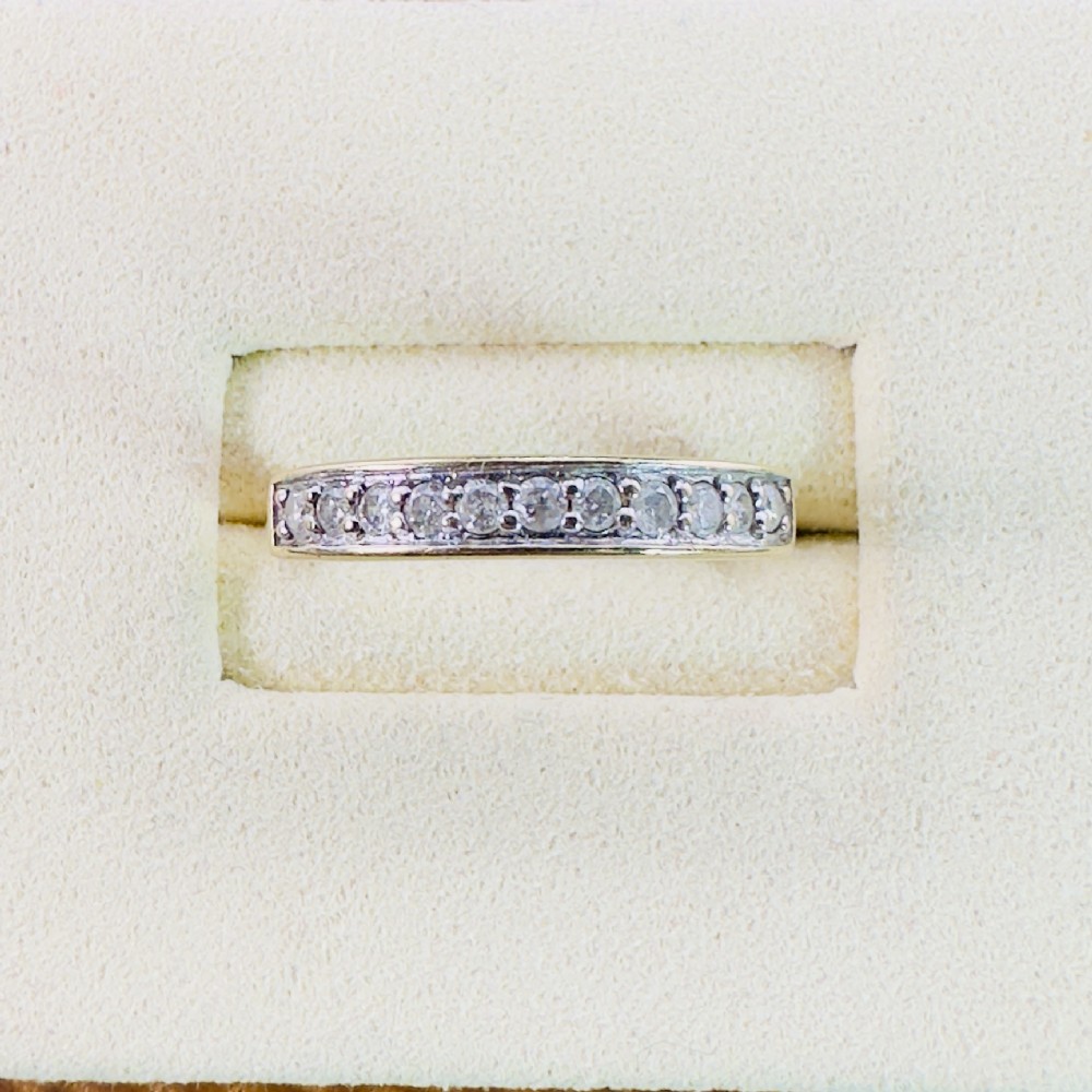 A 9ct gold half eternity ring set with eleven round brilliant cut diamonds along the top of the band.