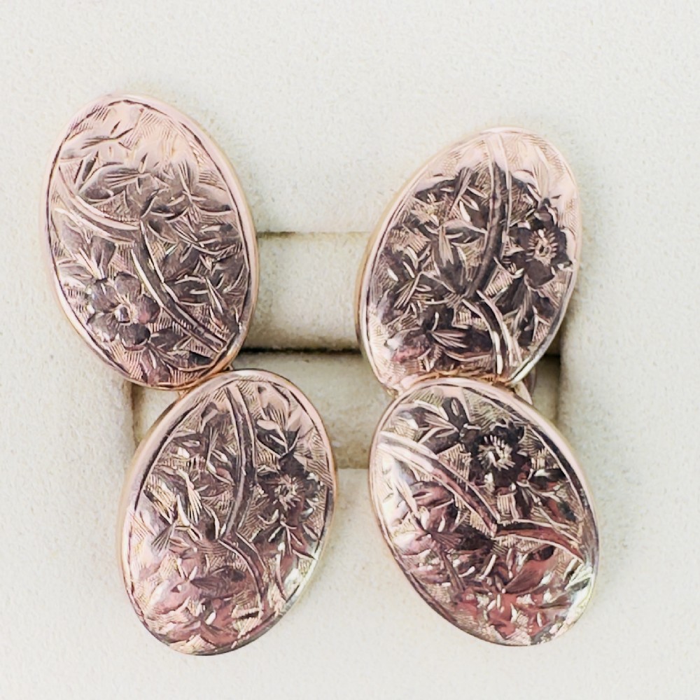 A pair of Victorian 9ct rose gold double-sided oval cufflinks decorated with hand-engraved floral motifs.
