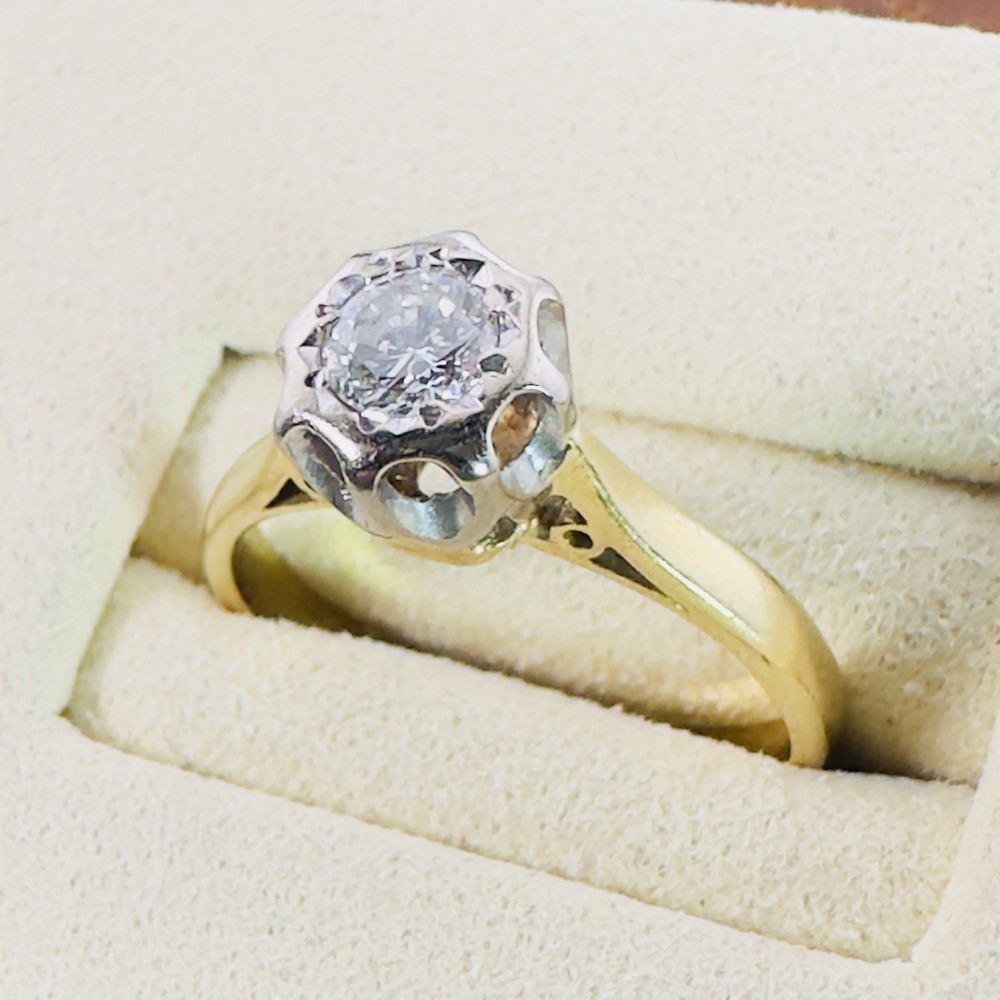 An 18ct yellow gold ring featuring a round diamond mounted within an octagonal illusion setting.