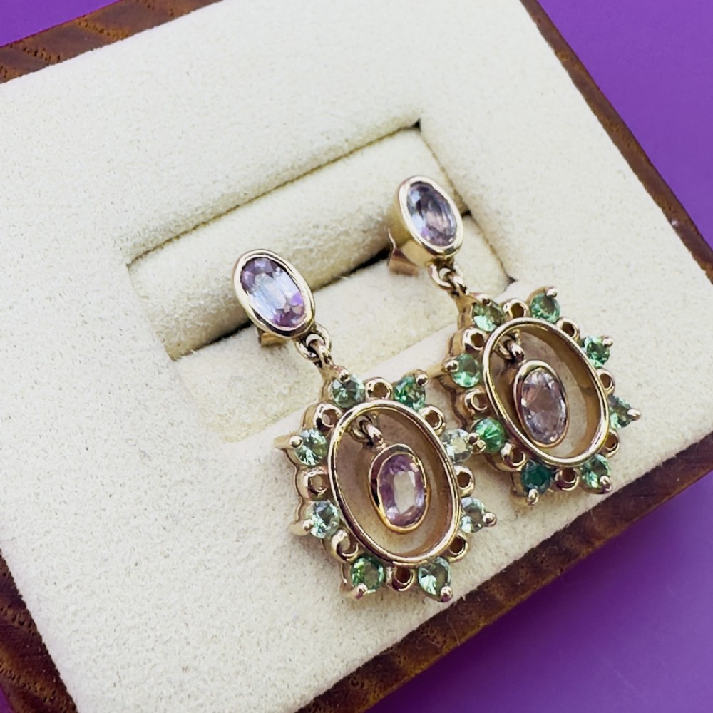 A pair of 9ct yellow gold drop earrings featuring oval pink sapphire studs suspending cluster drops set with green peridots and central pink sapphires.
