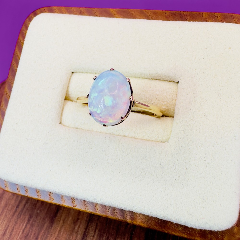 An 18ct yellow gold Victorian solitaire ring featuring an oval cabochon opal secured in a claw setting.