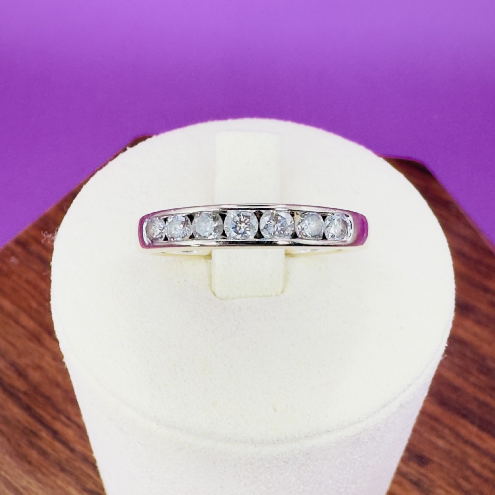 An 18ct white gold half eternity ring featuring seven round brilliant diamonds set horizontally into the band.