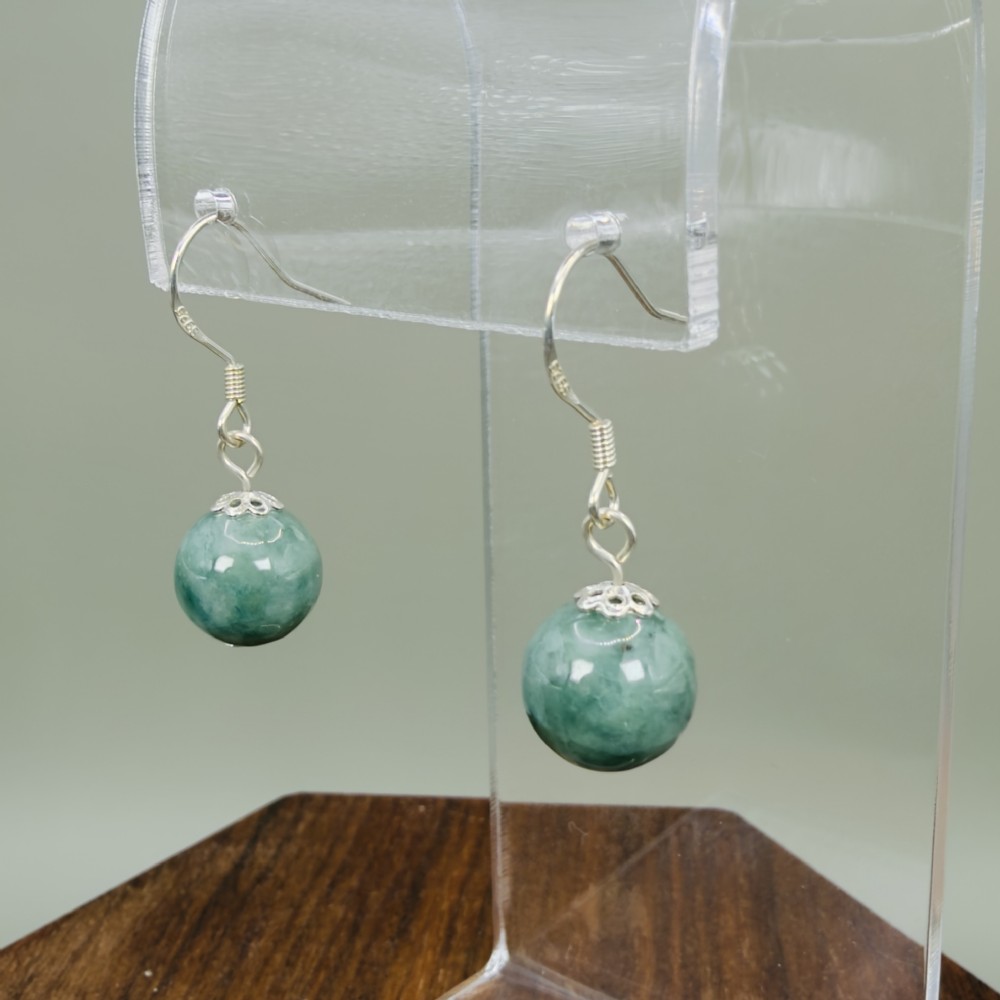 A pair of spherical green jade bead dangle earrings with ornate sterling silver caps and wire hook fittings. View II