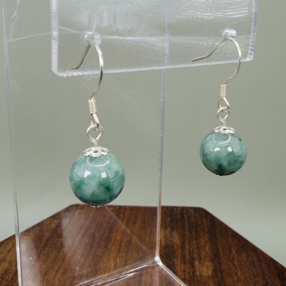 A pair of spherical green jade bead dangle earrings with ornate sterling silver caps and wire hook fittings. View III