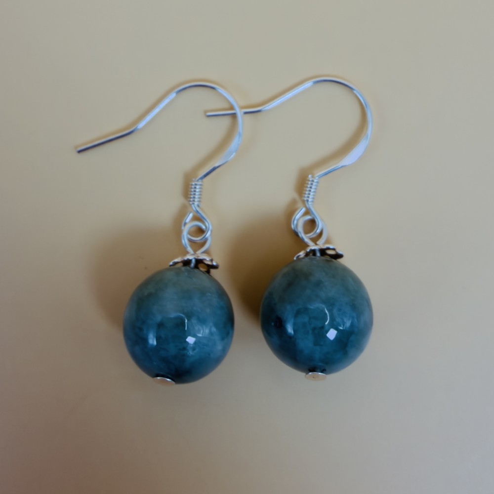A pair of spherical green jade bead dangle earrings with ornate sterling silver caps and wire hook fittings. View IV