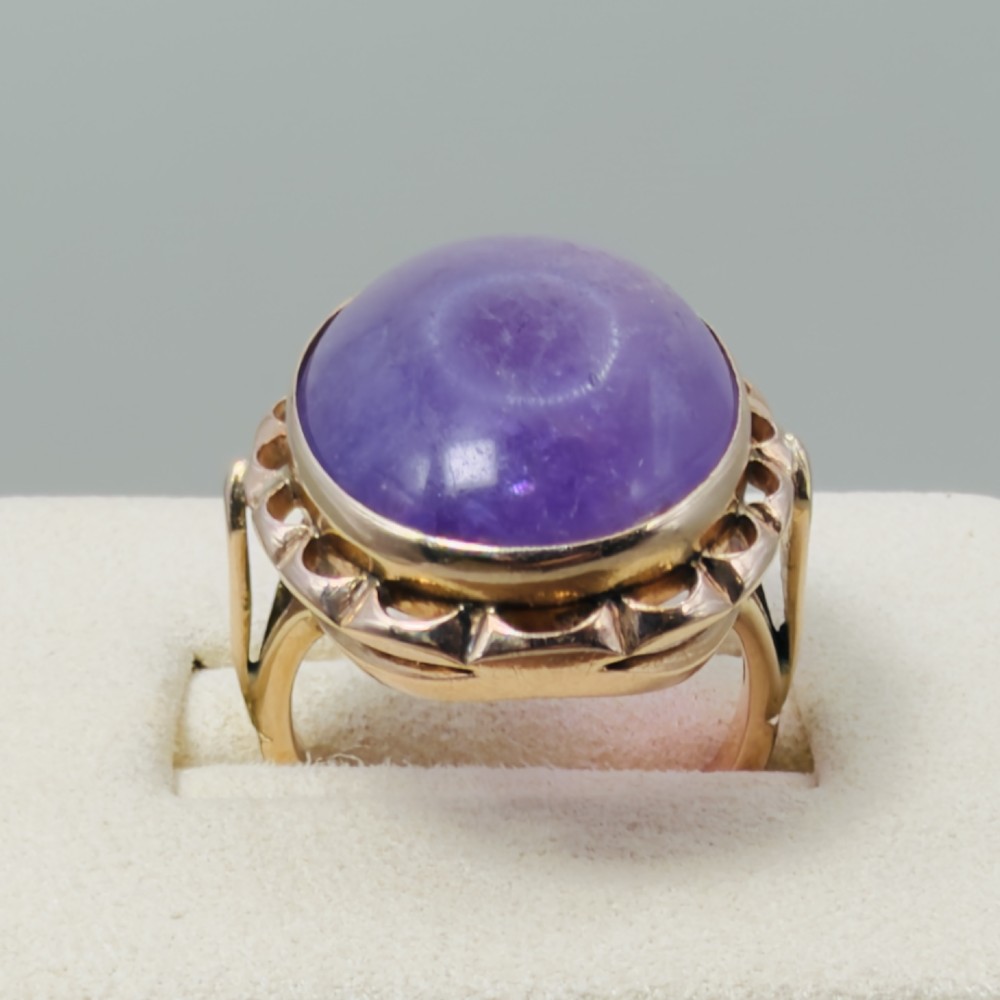 A vintage 14ct rose gold dress ring featuring a large oval cabochon lavender jade gemstone set within a scalloped gold gallery. View V