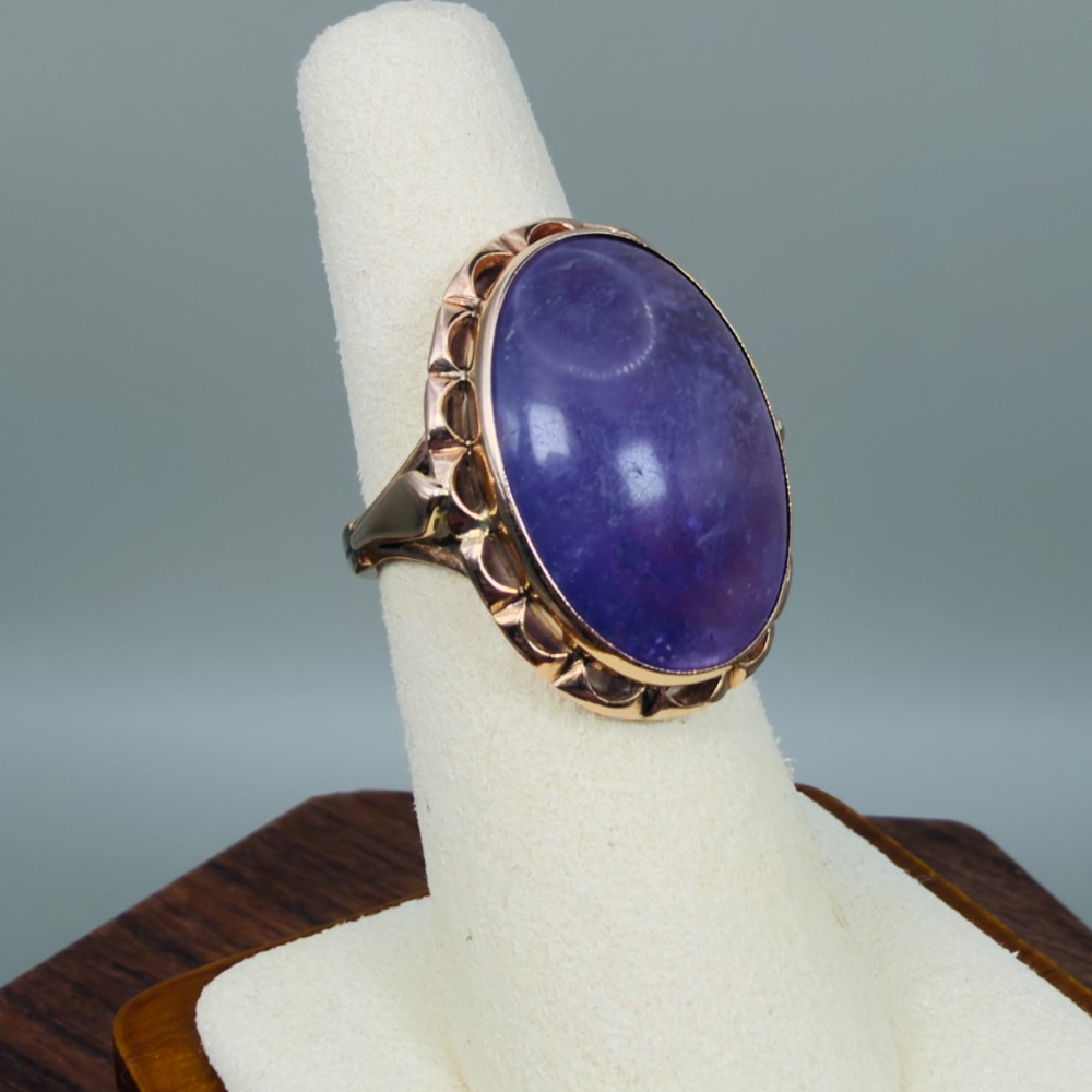 A vintage 14ct rose gold dress ring featuring a large oval cabochon lavender jade gemstone set within a scalloped gold gallery. View VIII