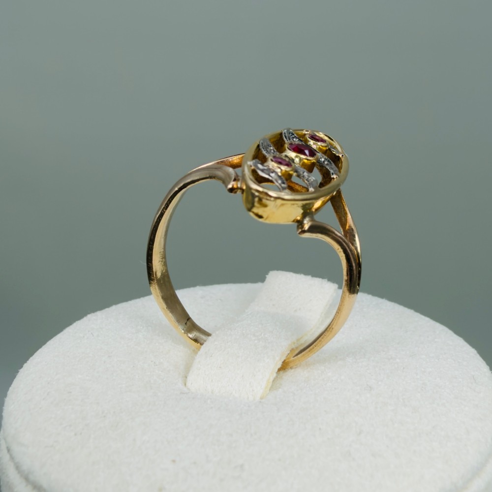 An 18ct gold Art Nouveau navette ring featuring three round rubies set within an openwork marquise-shaped mount detailed with diamonds. View VIII