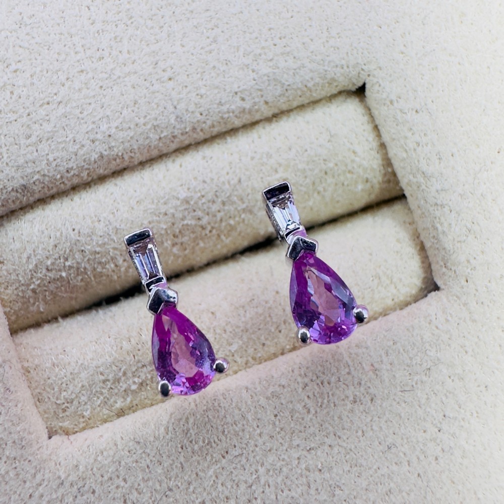 A pair of 18ct white gold stud earrings featuring pear-cut pink sapphires suspended beneath trapezoid-cut diamonds.