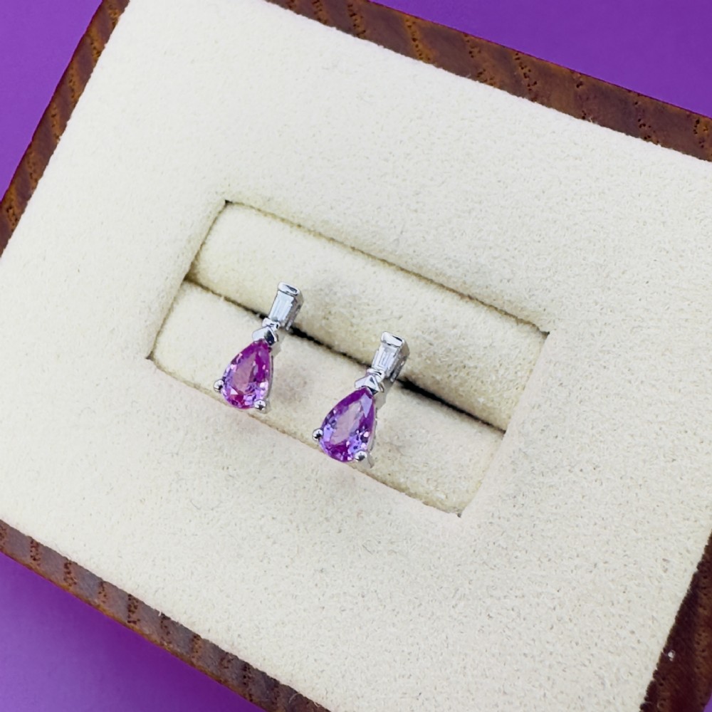 A pair of 18ct white gold stud earrings featuring pear-cut pink sapphires suspended beneath trapezoid-cut diamonds. View V