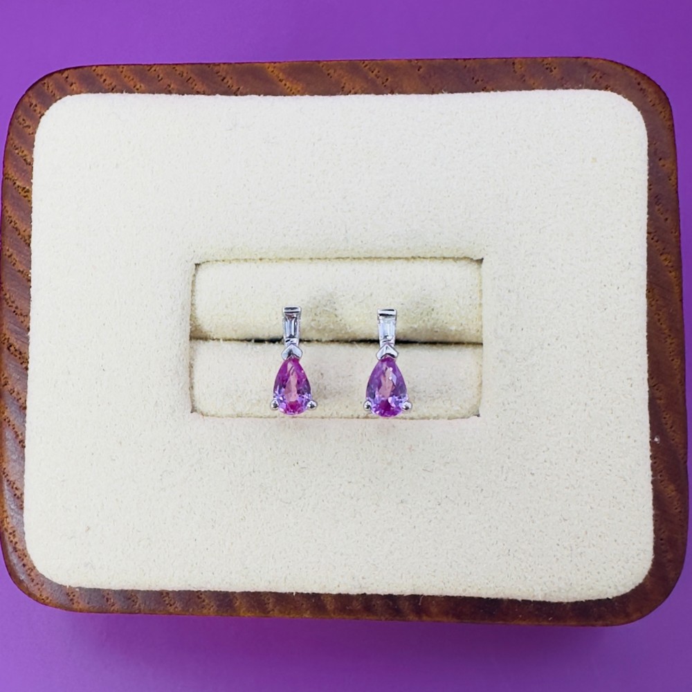 A pair of 18ct white gold stud earrings featuring pear-cut pink sapphires suspended beneath trapezoid-cut diamonds. View VI