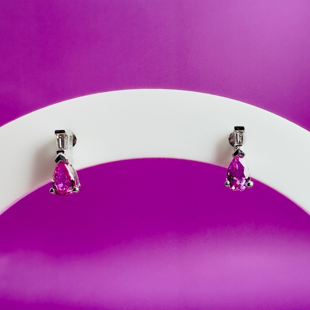 A pair of 18ct white gold stud earrings featuring pear-cut pink sapphires suspended beneath trapezoid-cut diamonds. View VII