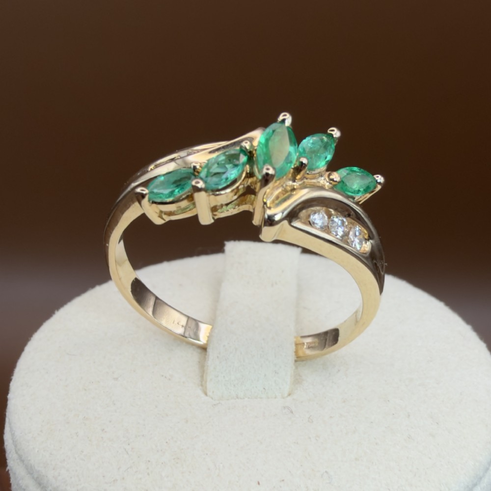 A 14ct yellow gold cluster ring set with five marquise-cut green emeralds flanked by channel-set diamonds. View XIII