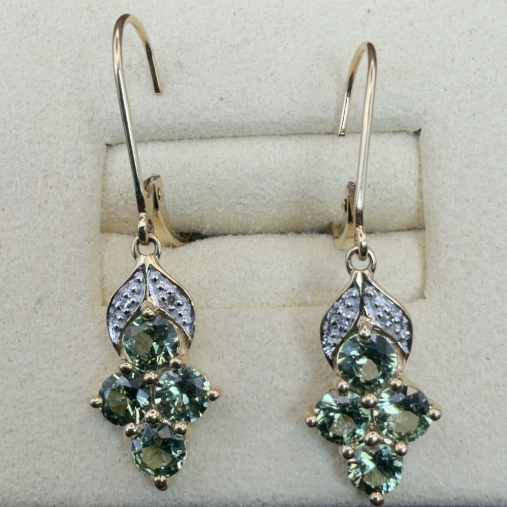 A pair of 9ct yellow gold drop earrings featuring a cluster of round-cut teal green sapphires suspended from hinge back hooks with diamond accent detail.