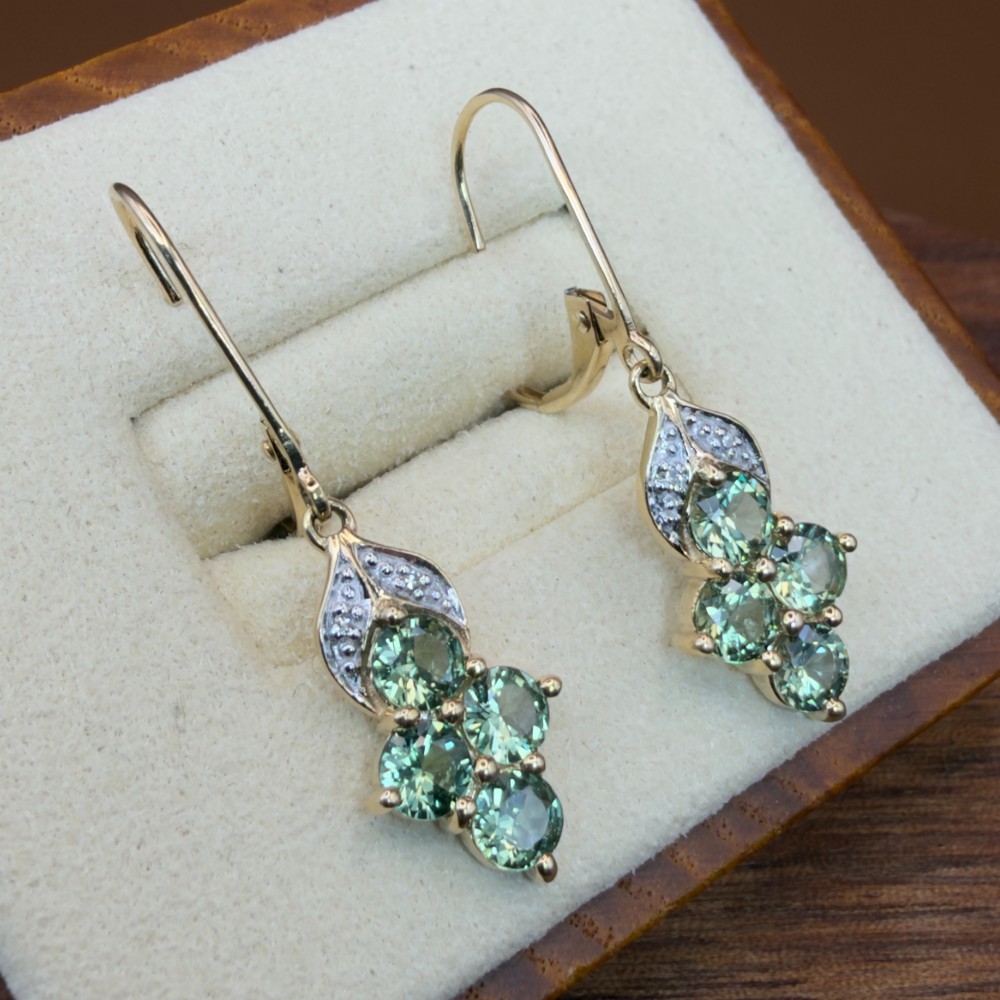 A pair of 9ct yellow gold drop earrings featuring a cluster of round-cut teal green sapphires suspended from hinge back hooks with diamond accent detail. View IV