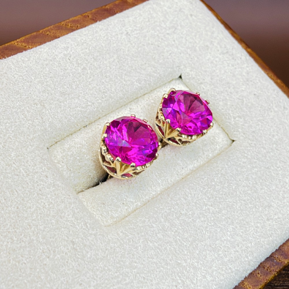 A pair of round pink sapphire gemstone stud earrings set in 18ct yellow gold claw settings with screw backs. View VI