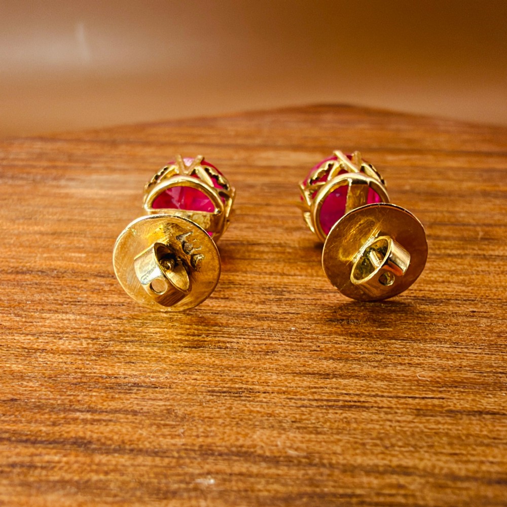 A pair of round pink sapphire gemstone stud earrings set in 18ct yellow gold claw settings with screw backs. View IX
