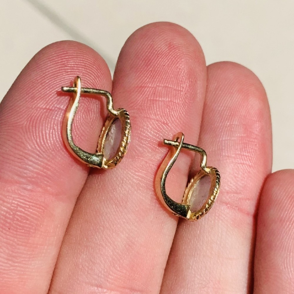 A pair of 14ct yellow gold stud earrings featuring oval cabochon opals surrounded by a textured rope-twist border. View V