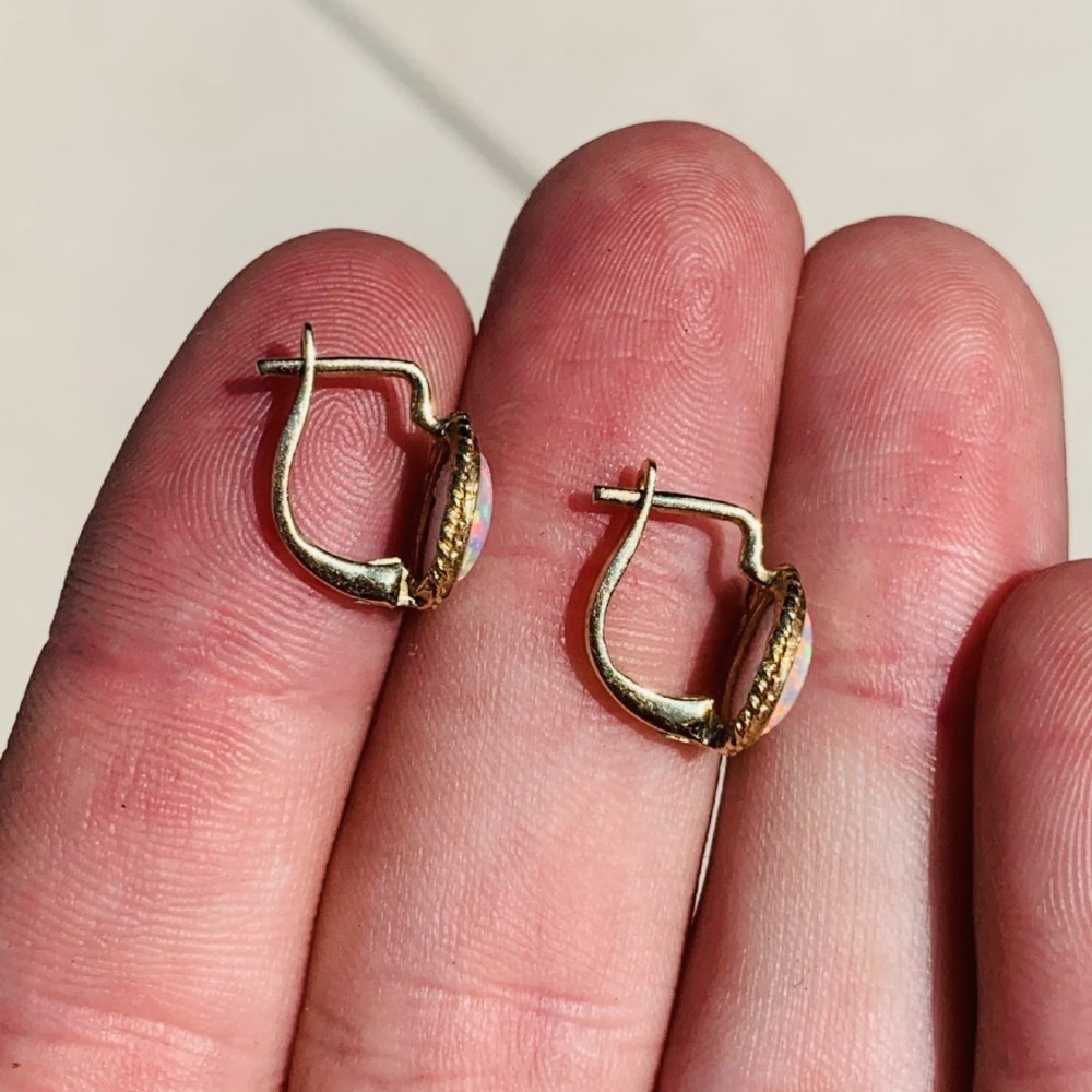 A pair of 14ct yellow gold stud earrings featuring oval cabochon opals surrounded by a textured rope-twist border. View VIII