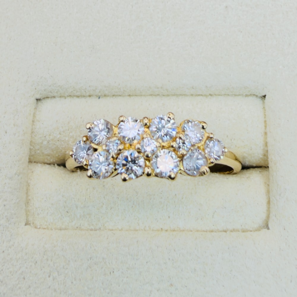 An 18ct yellow gold Art Deco cluster ring set with ten old European cut diamonds arranged in a contoured multi-row setting.
