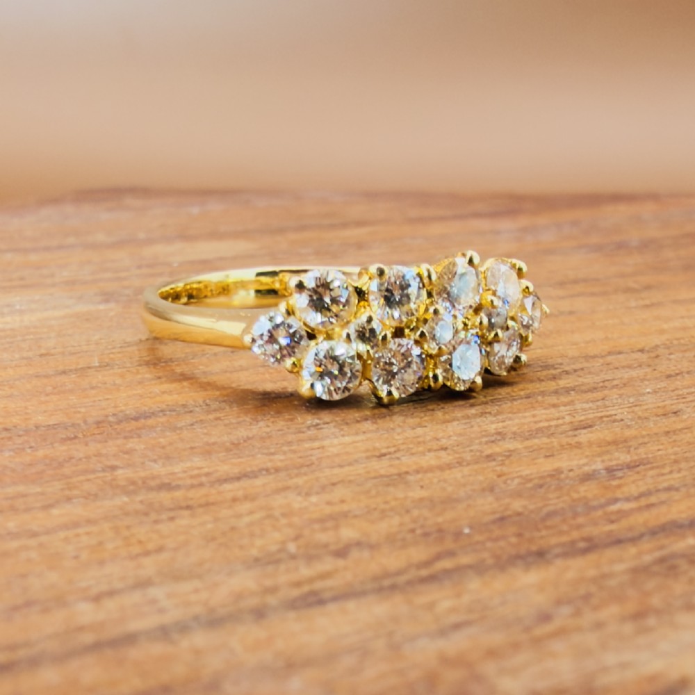An 18ct yellow gold Art Deco cluster ring set with ten old European cut diamonds arranged in a contoured multi-row setting. View X