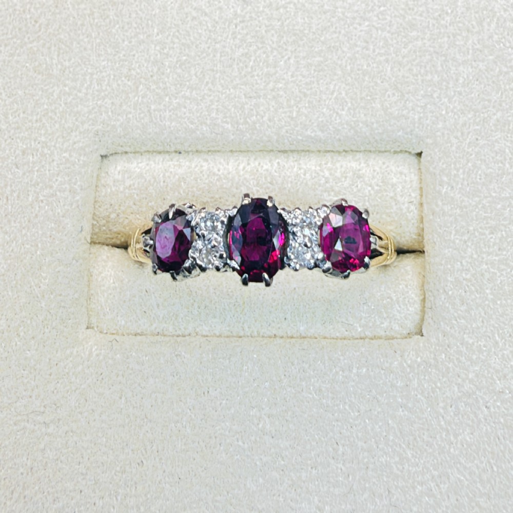 An 18ct yellow gold ring featuring three oval red rubies separated by pairs of small diamonds set in a claw setting. View II