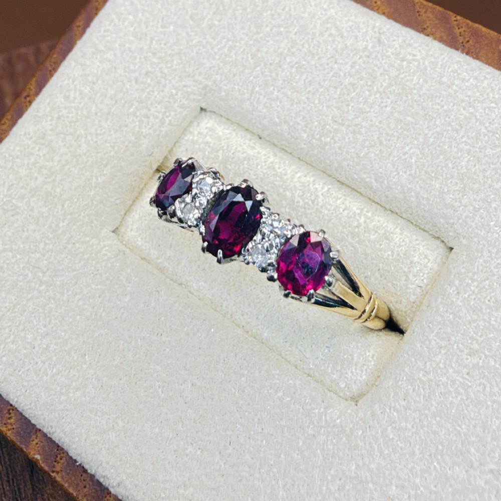 An 18ct yellow gold ring featuring three oval red rubies separated by pairs of small diamonds set in a claw setting. View III