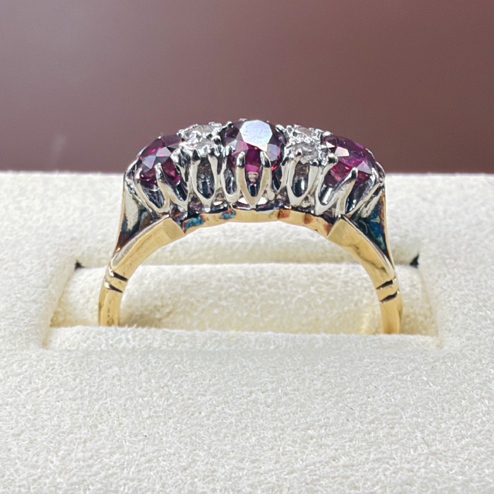 An 18ct yellow gold ring featuring three oval red rubies separated by pairs of small diamonds set in a claw setting. View V