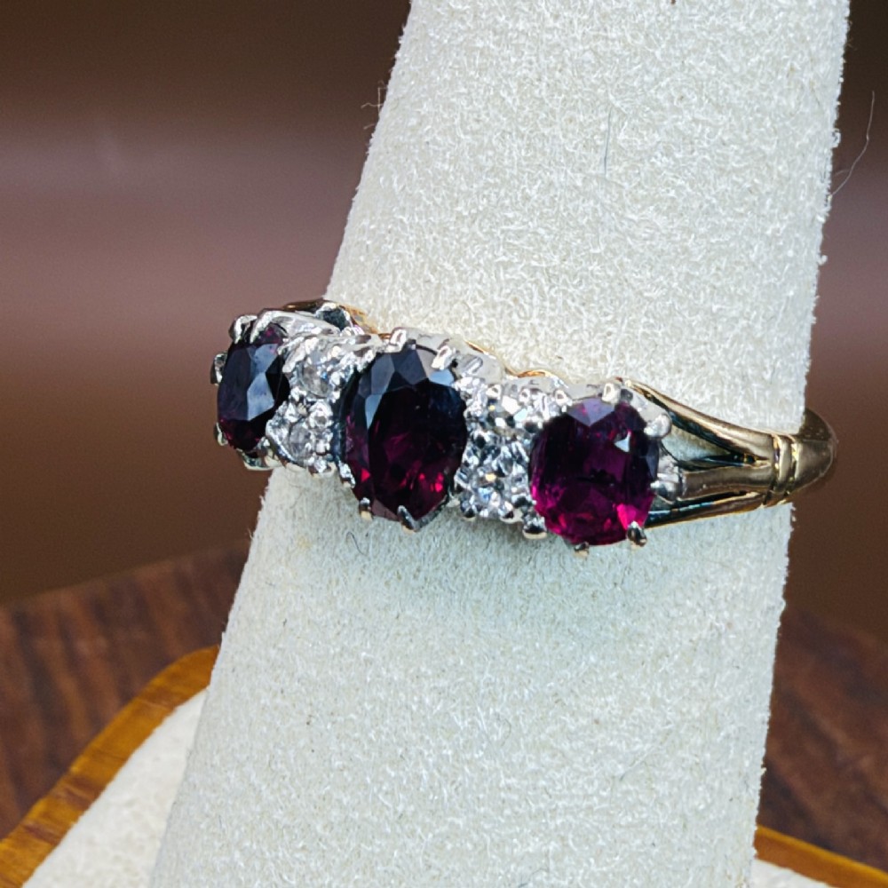 An 18ct yellow gold ring featuring three oval red rubies separated by pairs of small diamonds set in a claw setting. View XI