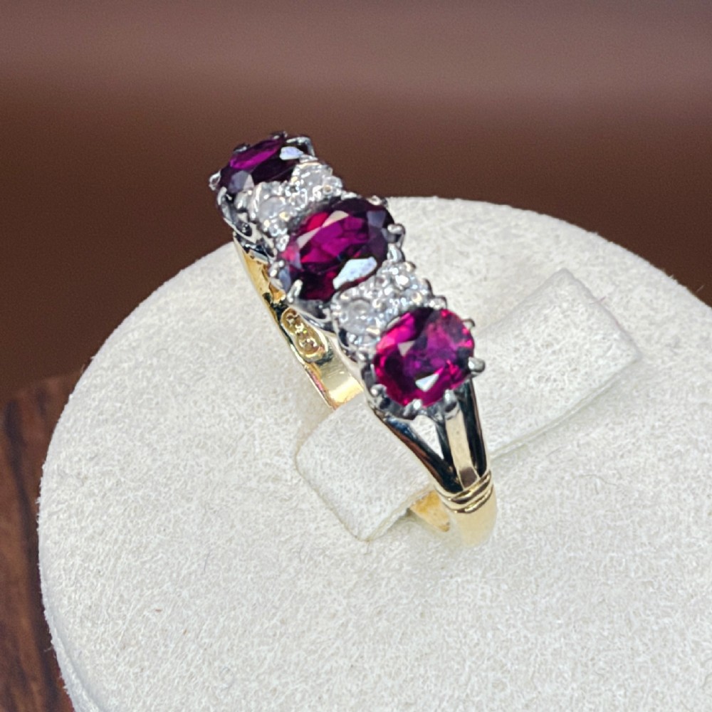 An 18ct yellow gold ring featuring three oval red rubies separated by pairs of small diamonds set in a claw setting. View XIII