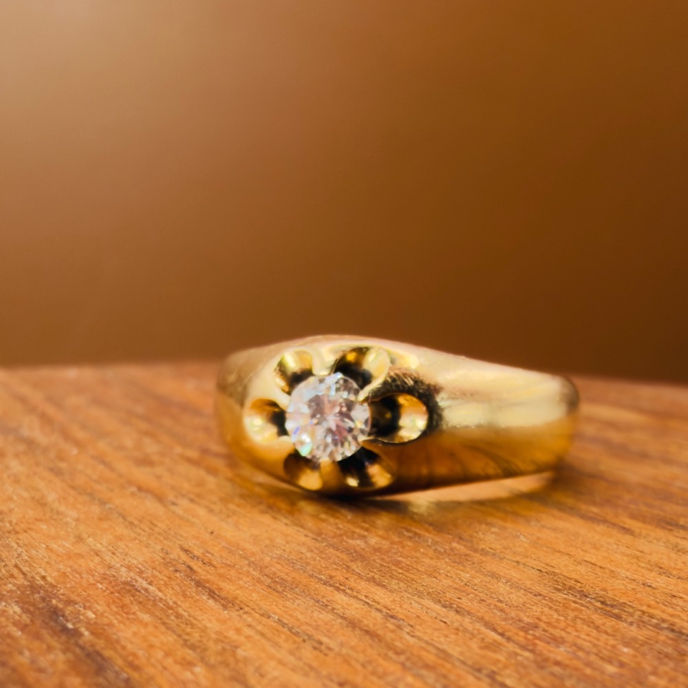 An 18ct yellow gold mens solitaire ring featuring a single diamond mounted in a carved starburst setting. View X