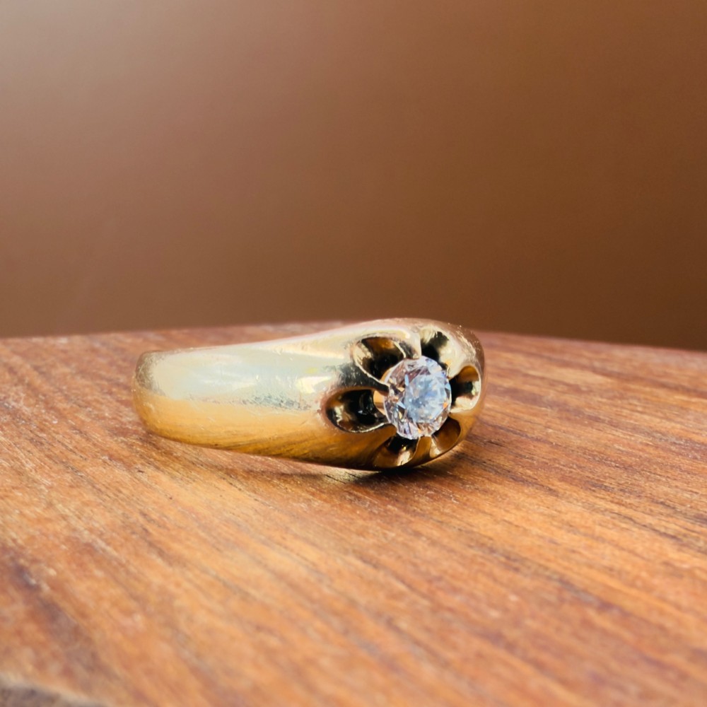 An 18ct yellow gold mens solitaire ring featuring a single diamond mounted in a carved starburst setting. View XI