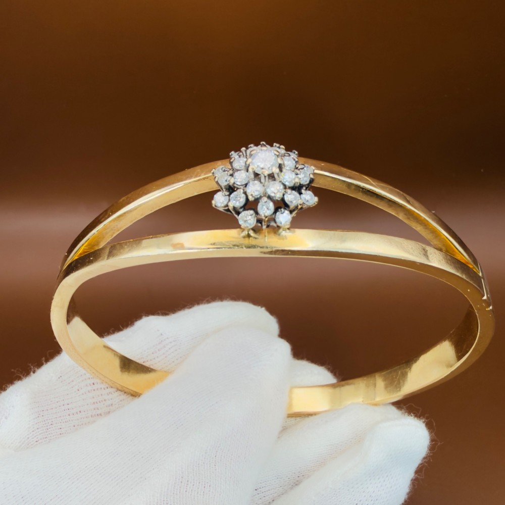 A solid 9ct yellow gold split-band cuff bangle featuring a central multi-stone diamond cluster set in a tiered round formation. View VI