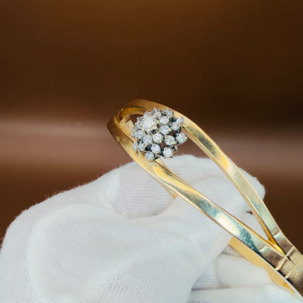 A solid 9ct yellow gold split-band cuff bangle featuring a central multi-stone diamond cluster set in a tiered round formation. View VII
