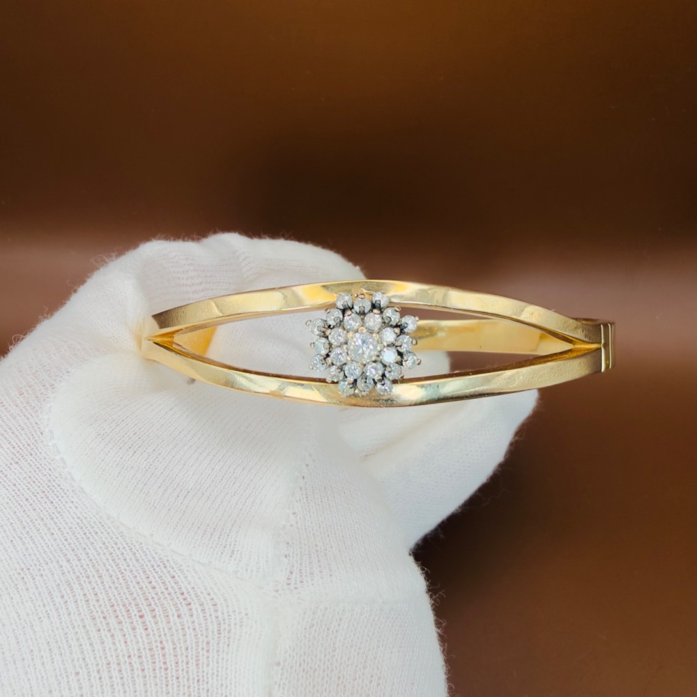 A solid 9ct yellow gold split-band cuff bangle featuring a central multi-stone diamond cluster set in a tiered round formation. View IX