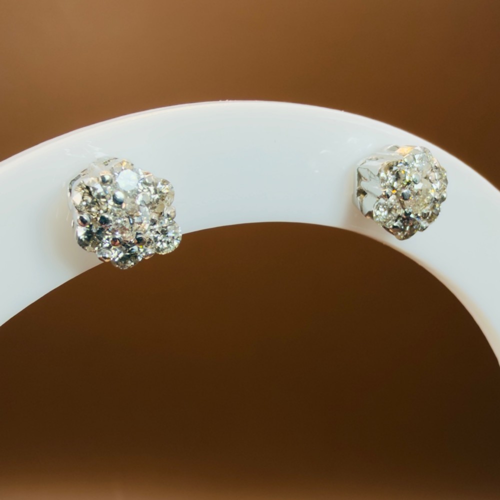 A pair of 18ct white gold cluster stud earrings featuring brilliant-cut diamonds arranged in a floral design. View IV