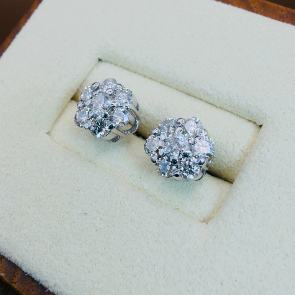 A pair of 18ct white gold cluster stud earrings featuring brilliant-cut diamonds arranged in a floral design. View VI