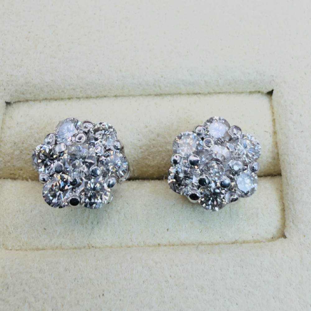 A pair of 18ct white gold cluster stud earrings featuring brilliant-cut diamonds arranged in a floral design.