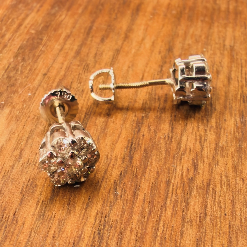 A pair of 18ct white gold cluster stud earrings featuring brilliant-cut diamonds arranged in a floral design. View IX